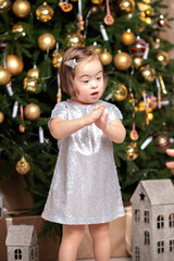 happy girl with down syndrome dancing near the christmas tree