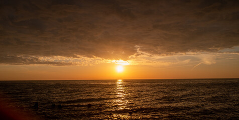 Amazing clouds in the sky on the sea and the rays of the setting sun