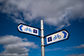 Cycle path direction signposts, cloud sky background