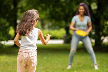 summer activities with children, mother and daughter in the park playing frisbee, happy childhood, african woman with child outdoor