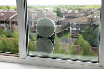 robot window cleaner on the glass from the street, device for cleaning windows in the house