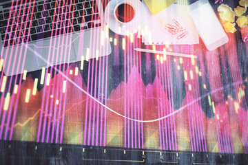 Financial market graph and top view computer on the desktop background. Double exposure. Investment concept.