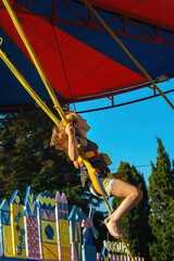 a girl of 8-10 years old is fastened with elastic bands and jumps on an attraction in a banjo park...