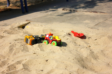 Children's toys, cars on the sand playground. Toys in the sandbox.