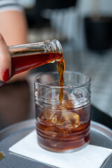 Pouring cold brew iced coffee in glass cup with ice cubes , coffee consept