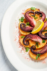 Octopus with potatoes and spices , on a light plate, top view, no people, homemade, close-up,