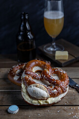 German Brezel pretzel with salt and butter and beer on wooden background. Oktoberfest