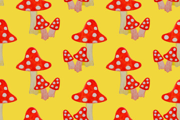 Painted watercolor mushrooms fly agaric on a yellow background. Seamless pattern.