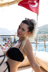 Beautiful Turkish young woman drinking coffee with pink drinking straw. She wears glittery make up. 