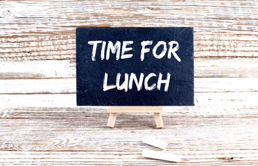 TIME FOR LUNCH text on the Miniature chalkboard on wooden background