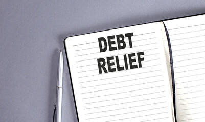 DEBT RELIEF word on the notebook with pen