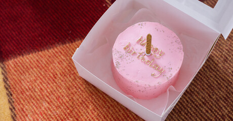 pink happy birthday cake with candle closeup