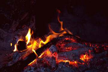 Romantic fireplace with a burning fire.
Burning logs in fire.  Flame of the fire warms and illuminates. 