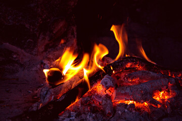 Romantic fireplace with a burning fire.
Burning logs in fire.  Flame of the fire warms and illuminates. 