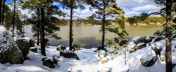 panoramic of lake at winter with snow and forest around with clouds in the sky, arareco lake in...