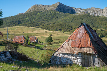 An old mountain village with roofs made of cut old barrels with a beautiful view of the landscape