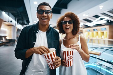 A couple in love, friends watching a movie with popcorn in the cinema.
