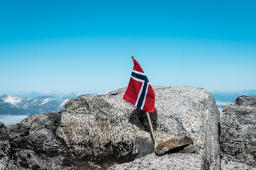 Norwegian flag in front of mountain view on clear blue sky