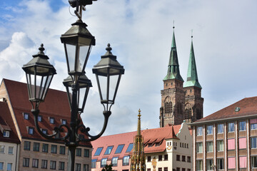 Fototapeta na wymiar Square in the City of Nuremberg with a lamp and a church in the background