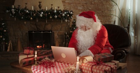 Santa Claus using laptop in living room