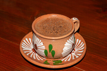 Traditional hot chocolate in a clay mug