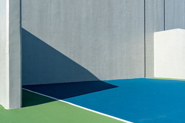 Example of an outside American Handball courts with concrete wall, located at a park or school.
