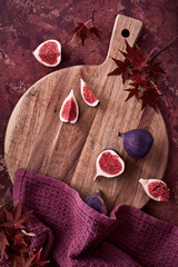 Panoramic banner Autumntime background with fresh halved fig fruits. Dry eucalyptus and cala lily...