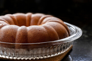 Just baked golden Rum Cake with syrup being brushed on for flavoring