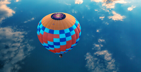 Hot air balloon over the blue sea. View from above