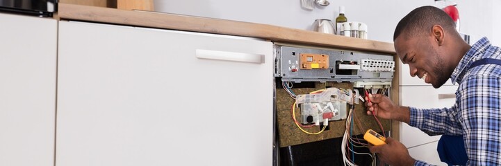 Technician Fixing Dishwasher With Digital Multimeter