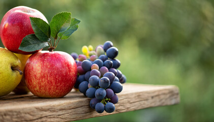 Autumn fruit still life, red apple, and yellow purple grapes on old wooden table.