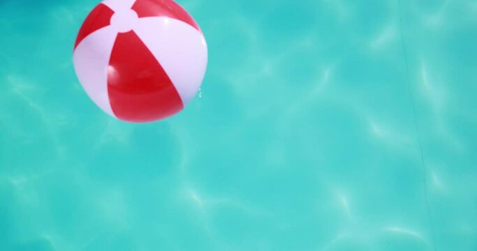Beach ball floating in swimming pool. Summer vacation concept