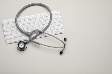 Keyboard and stethoscope on beige background, flat lay. Space for text - obrazy, fototapety, plakaty