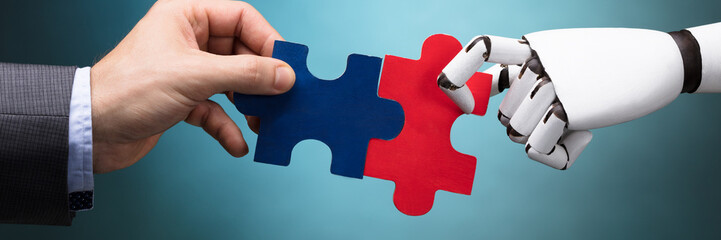 Businessperson And Robot Holding Jigsaw Puzzle