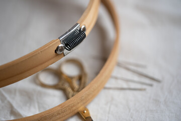 aros de madera para bordar con tijeras de cigüeña para hilo sobre madera blanca y tela