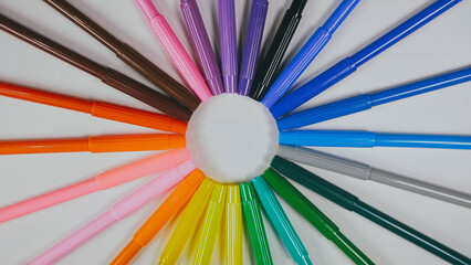 Many colored pencils are arranged around the edges of the image as a frame. In the center is an empty background with space for text. Mock up with copy space.