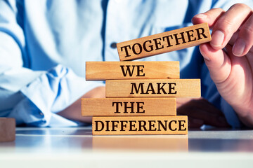Wooden blocks with words 'TOGETHER WE MAKE THE DIFFERENCE'. - obrazy, fototapety, plakaty