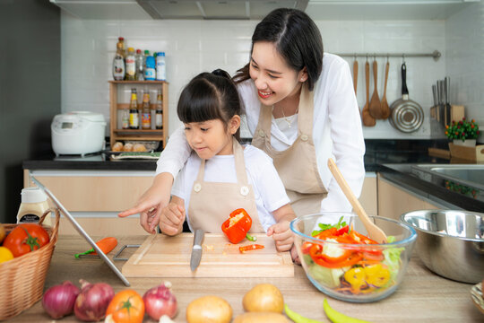Asian mother and her daughter enjoy cooking togather