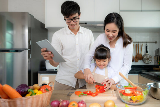 Asian family and her daughter enjoy cooking togather