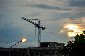 Crane tower at the construction site during sunset