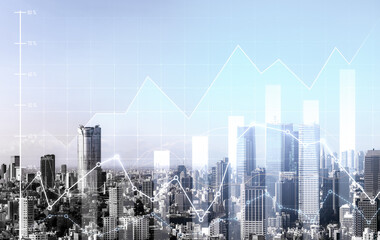 As background for a financial or business concept, digital screen and financial graphs overlap on a picture of modernistic cityscape, skyscrabbers.