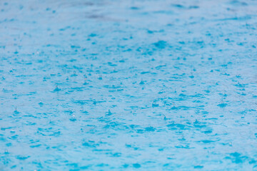 Surface of blue water in heavy rain.