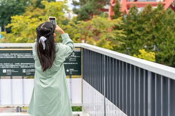 旅行中にスマホで撮影をしている日本人の女の子