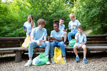 A multiethnic group of people, cleaning together in a public park, are protecting the environment. The concept of recycling and cleaning