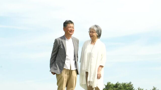 話しながら歩く日本人の高齢者夫婦（空）
