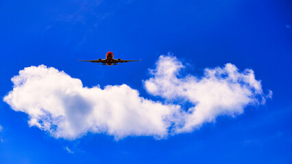 Fototapeta na wymiar 青空に浮かぶ白い雲と飛行機合成