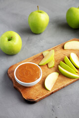 Homemade Caramel Apple Dip on a rustic wooden board, low angle view.