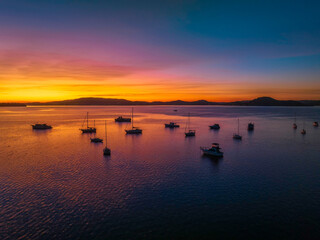 Obraz premium Aerial sunrise waterscape with boats and high cloud