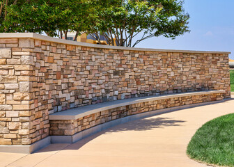 A decorative curved fence wall with built in bench.