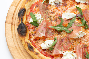 Delicious Italian pizza with ham, cheese, arugula and tomatoes.
